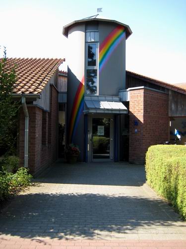 Eingang des Kindergarten Regenbogen mit gemaltem Regenbogen am Turm